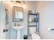 Compact half bathroom featuring pedestal sink, floating shelves, and a modern vanity mirror at 2469 S Sailors Ct, Gilbert, AZ 85295