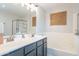 Bathroom featuring double sinks, a soaking tub, and a glass-enclosed shower at 2469 S Sailors Ct, Gilbert, AZ 85295