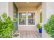 Cozy covered front porch with neutral-striped welcome mat and vibrant potted plants at 2469 S Sailors Ct, Gilbert, AZ 85295