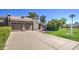 Well-maintained single-story home showcasing a concrete driveway, lush lawn, and mature landscaping at 25273 S Berry Brook Dr, Sun Lakes, AZ 85248