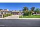 Attractive single-story home featuring a manicured lawn, mature shrubs, and a convenient two-car garage at 25273 S Berry Brook Dr, Sun Lakes, AZ 85248