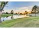 Peaceful pond with a fountain feature, lush green grass, and trees under a bright sky at 25273 S Berry Brook Dr, Sun Lakes, AZ 85248