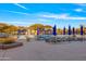 Community pool area featuring sun loungers, umbrellas, and cabanas under a partly cloudy sky at 2550 W Pumpkin Ridge Dr, Anthem, AZ 85086