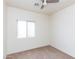 Bright bedroom featuring neutral carpet, a ceiling fan, and a window at 2624 E La Costa Dr, Chandler, AZ 85249