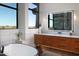 Spa-like bathroom with a soaking tub, sleek vanity, and expansive windows overlooking the desert scenery at 29218 N 107Th Way, Scottsdale, AZ 85262