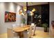 Chic dining room featuring a striking chandelier, a unique wooden table, and colorful modern artwork on the wall at 29218 N 107Th Way, Scottsdale, AZ 85262