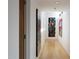 Bright hallway with hardwood floors and striking artwork, leading to various rooms in the home at 29218 N 107Th Way, Scottsdale, AZ 85262