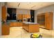 A modern kitchen with a central island, light wood cabinets, stainless steel appliances, and an adjacent dining area at 29218 N 107Th Way, Scottsdale, AZ 85262