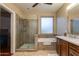 Updated bathroom with a glass shower, soaking tub, and a modern vanity with stylish fixtures at 29374 N 68Th Ln, Peoria, AZ 85383