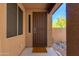 A protected entrance featuring a secure decorative metal door, welcome mat, and adjacent rock garden at 29374 N 68Th Ln, Peoria, AZ 85383