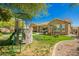 Outdoor fun awaits with this backyard playset, complete with a slide and climbing features on a grassy lawn at 3046 E Athena Ave, Gilbert, AZ 85297