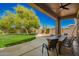 Enjoy outdoor dining on this covered patio with a large table overlooking the expansive backyard at 3046 E Athena Ave, Gilbert, AZ 85297