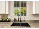 Kitchen sink with a window view, decorative flowers, and granite countertops at 3046 E Athena Ave, Gilbert, AZ 85297
