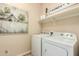 Functional laundry room with white washer and dryer and charming farmhouse-style decor above at 3046 E Athena Ave, Gilbert, AZ 85297