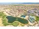 Aerial view of a vibrant neighborhood with a community lake, pool, and golf course, offering a desirable lifestyle at 31013 N Claridge Cir, San Tan Valley, AZ 85143