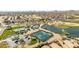Aerial of community amenities featuring pool, tennis courts, lake, and lush golf course with mountain views at 31013 N Claridge Cir, San Tan Valley, AZ 85143