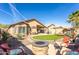 This backyard features an outdoor fire pit, covered patio, synthetic grass, desert plants, and lounge furniture at 31013 N Claridge Cir, San Tan Valley, AZ 85143