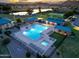 Aerial evening view of community pool, hot tub, BBQ, and picnic areas with mountain sunset in background at 31013 N Claridge Cir, San Tan Valley, AZ 85143