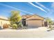 Charming single-Gathering home featuring desert landscaping, a beige stucco exterior, and a two-car garage at 31013 N Claridge Cir, San Tan Valley, AZ 85143
