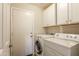Laundry room features a washer, dryer, storage cabinets, and access door at 31013 N Claridge Cir, San Tan Valley, AZ 85143