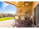 Covered patio with stylish outdoor furniture, ceiling fan, decorative wall art, and view to the backyard and landscaping at 31013 N Claridge Cir, San Tan Valley, AZ 85143