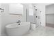 Elegant bathroom featuring a freestanding tub, a frameless glass shower, and marble-look tile at 37650 W Nina St, Maricopa, AZ 85138