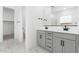 Well-lit bathroom with double sink vanity, stone floors, and ample storage at 37650 W Nina St, Maricopa, AZ 85138