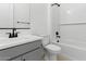 A well-lit bathroom with white subway tile, gray vanity, and modern fixtures, offering a clean and stylish design at 37650 W Nina St, Maricopa, AZ 85138