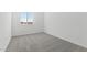 An empty bedroom with gray carpet, white walls, and a window, ready for customization and personalization at 37650 W Nina St, Maricopa, AZ 85138