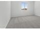 An empty bedroom with gray carpet, white walls, and a window, ready for customization and personalization at 37650 W Nina St, Maricopa, AZ 85138