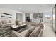 Open-concept living room with modern furnishings and a view of the kitchen area, offering a stylish and inviting atmosphere at 37650 W Nina St, Maricopa, AZ 85138