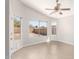 An empty bonus room features tile flooring, neutral paint, a ceiling fan, and bright windows at 3805 S 73Rd Dr, Phoenix, AZ 85043