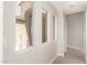 Bright hallway featuring tile flooring, neutral paint, a few windows, and white trim and doors at 3805 S 73Rd Dr, Phoenix, AZ 85043