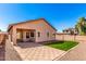 Backyard with artificial grass lawn and covered patio at 41444 W Capistrano Dr, Maricopa, AZ 85138