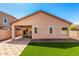 Backyard with artificial grass, pavers, and covered patio at 41444 W Capistrano Dr, Maricopa, AZ 85138