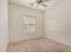 Neutral bedroom with a ceiling fan, window, and carpet flooring at 41444 W Capistrano Dr, Maricopa, AZ 85138
