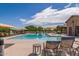 Inviting community pool with comfortable lounge chairs, umbrellas, and a covered seating area for relaxation at 41444 W Capistrano Dr, Maricopa, AZ 85138
