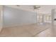 Bright living room with carpet, adjacent tile flooring, ceiling fan, and ample natural light at 41444 W Capistrano Dr, Maricopa, AZ 85138