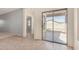 Bright living room with carpet, tile flooring, a sliding glass door and access to other rooms at 41444 W Capistrano Dr, Maricopa, AZ 85138