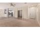 Open-concept living room with carpet, connecting to a kitchen and tile entryway at 41444 W Capistrano Dr, Maricopa, AZ 85138