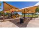 Community playground featuring slides, climbing structures, and covered picnic tables for a fun outdoor experience at 41444 W Capistrano Dr, Maricopa, AZ 85138