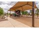 Community playground with various play structures and a shaded area, ideal for entertainment at 41444 W Capistrano Dr, Maricopa, AZ 85138