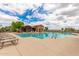Beautiful community pool surrounded by lounge chairs, perfect for relaxation and recreation at 41444 W Capistrano Dr, Maricopa, AZ 85138