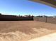 Large backyard with dirt and a privacy wall at 43372 N Wollemi St, Queen Creek, AZ 85140