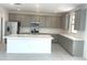 Spacious kitchen with gray cabinets, white quartz countertops, stainless steel appliances, and a large center island at 43372 N Wollemi St, Queen Creek, AZ 85140