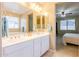 Bright bathroom features a double sink vanity with white cabinetry and tan tile flooring at 4557 W South Butte Rd, San Tan Valley, AZ 85144