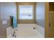 Bathroom with separate tub and shower featuring chrome fixtures and tiled walls at 4557 W South Butte Rd, San Tan Valley, AZ 85144