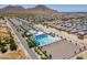 Aerial view of community pool and center surrounded by parking, landscaping, and desert neighborhood at 4557 W South Butte Rd, San Tan Valley, AZ 85144