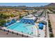 Aerial view of community pool with blue canopies, surrounded by desert landscaping and parking at 4557 W South Butte Rd, San Tan Valley, AZ 85144