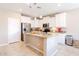 Bright kitchen with white cabinets, stainless steel appliances, and a large island with granite countertops at 4557 W South Butte Rd, San Tan Valley, AZ 85144